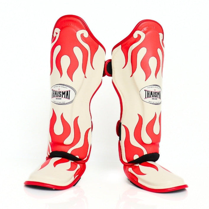 Red and white flame-patterned shin guards with 'Thaismai' branding on a white background
