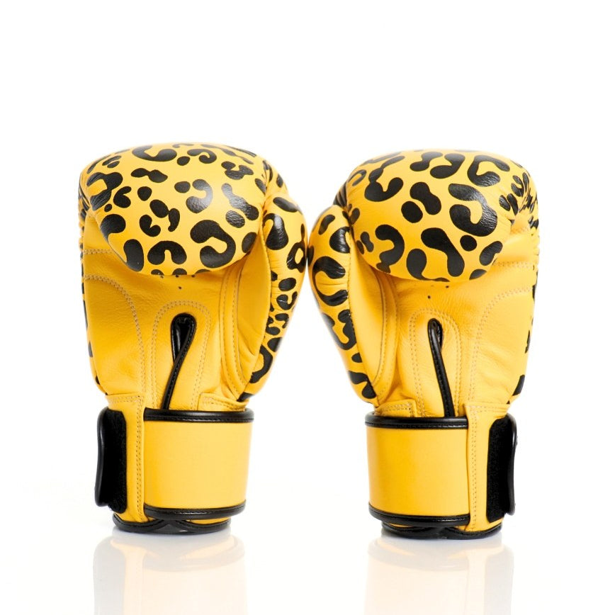 Yellow boxing gloves with black leopard print pattern on a white background