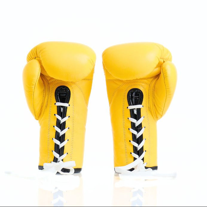 Pair of yellow boxing gloves with black and white accents on a white background