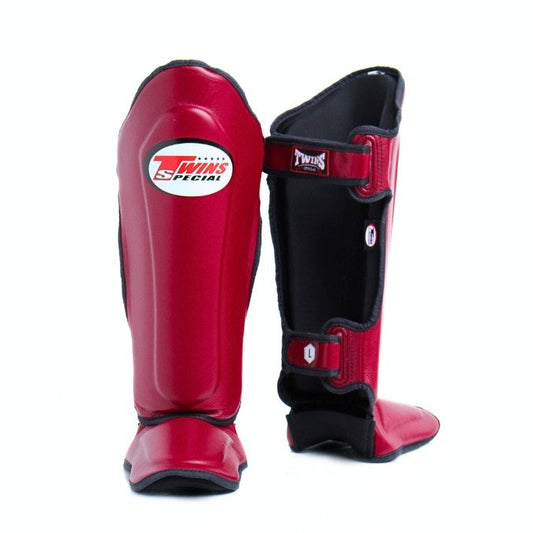 Red and black shin guards with a brand logo on a white background