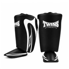A pair of black shin guards with white graphic accents and the 'Twins Special' logo, displayed on a clean white background.