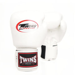 A pair of white Twins Special boxing gloves on a clean white background, showing the front glove with its red and black logo and the rear glove showing its strap closure.