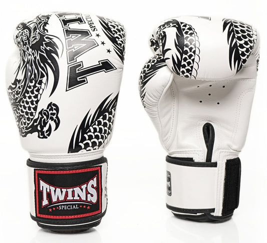 A pair of Twins Special boxing gloves shown from the front and back on a white background. The gloves are primarily white with black dragon illustrations and a black wrist strap featuring a red and white Twins logo patch.